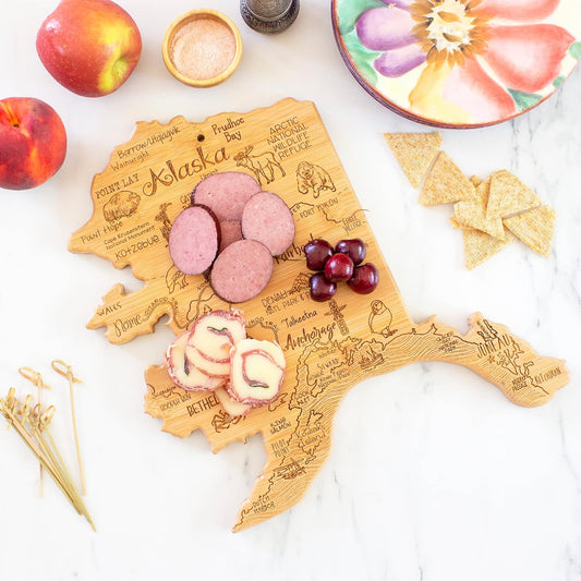 Destination Alaska State Shaped Cutting Board | State charcuterie serving board with engraved map artwork. Smooth reverse side for food prep. Hang tie for wall display.