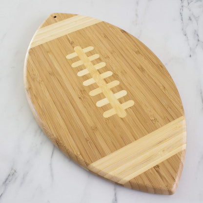 Football Shaped Bamboo Wood Cutting Board and Charcuterie Board, Great Gift for Football Fans | Football serving board for game day watch parties and tailgating. Smooth reverse side for prep. Hangs as decor between uses.