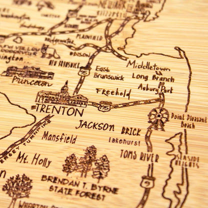 A Slice of Life New Jersey Engraved Map Cutting Board | 11” x 8.75” charcuterie board with engraved state map artwork. Smooth reverse side for food prep. Hang tie for wall display. - Colors B