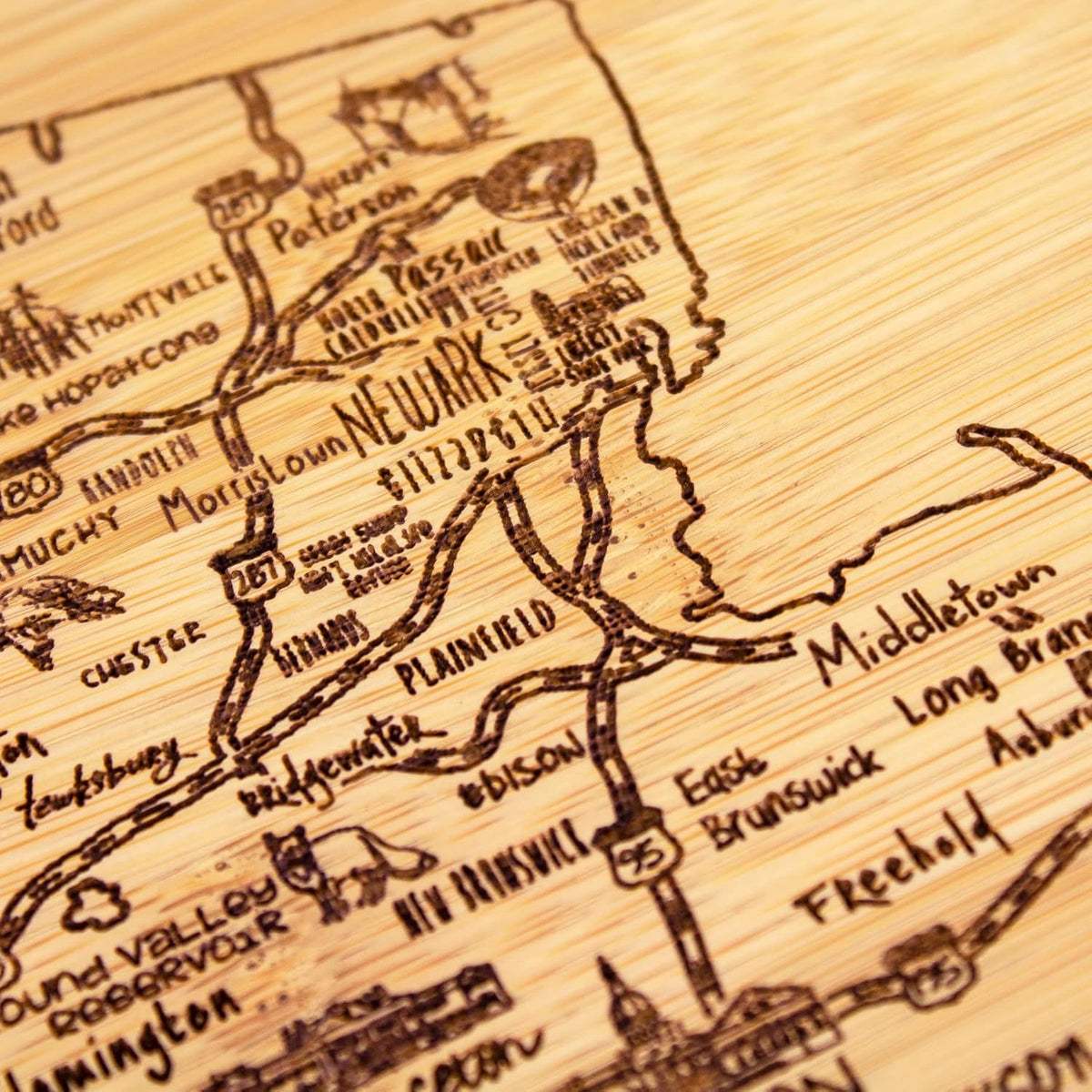 A Slice of Life New Jersey Engraved Map Cutting Board | 11” x 8.75” charcuterie board with engraved state map artwork. Smooth reverse side for food prep. Hang tie for wall display. - Colors B
