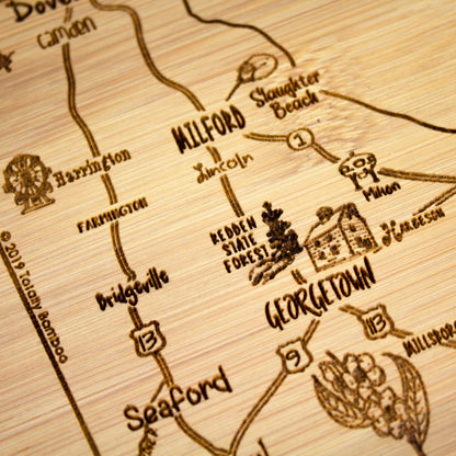 A Slice of Life New Jersey Engraved Map Cutting Board | 11” x 8.75” charcuterie board with engraved state map artwork. Smooth reverse side for food prep. Hang tie for wall display. - Colors B