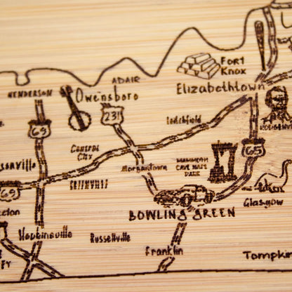 A Slice of Life New Jersey Engraved Map Cutting Board | 11” x 8.75” charcuterie board with engraved state map artwork. Smooth reverse side for food prep. Hang tie for wall display. - Colors B