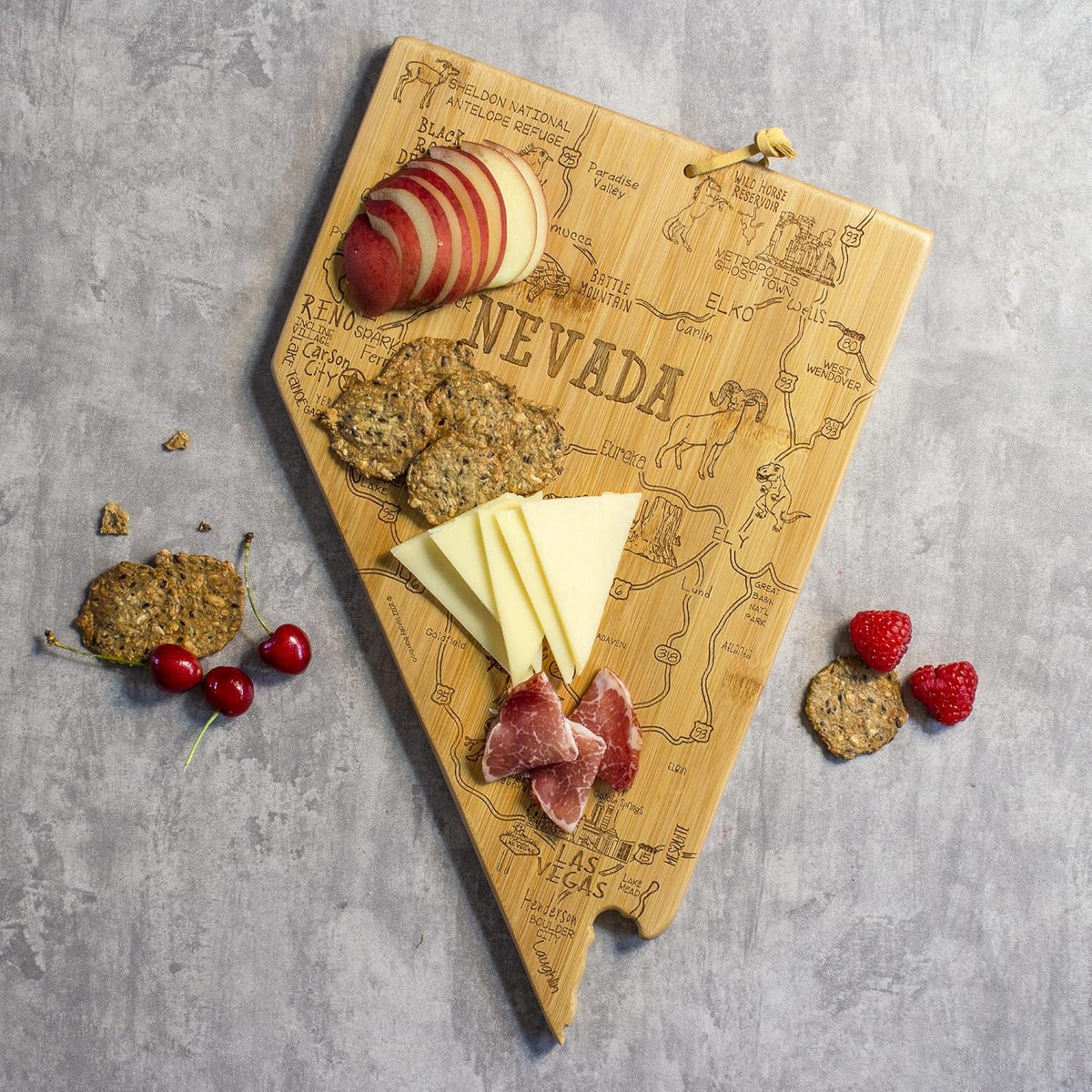 Destination Nevada State Shaped Cutting Board | State charcuterie serving board with engraved map artwork. Smooth reverse side for food prep. Hang tie for wall display.