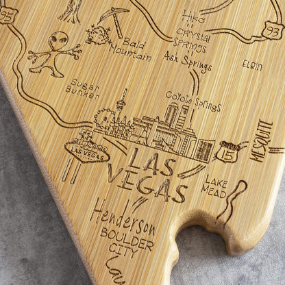 Destination Nevada State Shaped Cutting Board | State charcuterie serving board with engraved map artwork. Smooth reverse side for food prep. Hang tie for wall display.