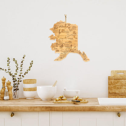 Destination Alaska State Shaped Cutting Board | State charcuterie serving board with engraved map artwork. Smooth reverse side for food prep. Hang tie for wall display.