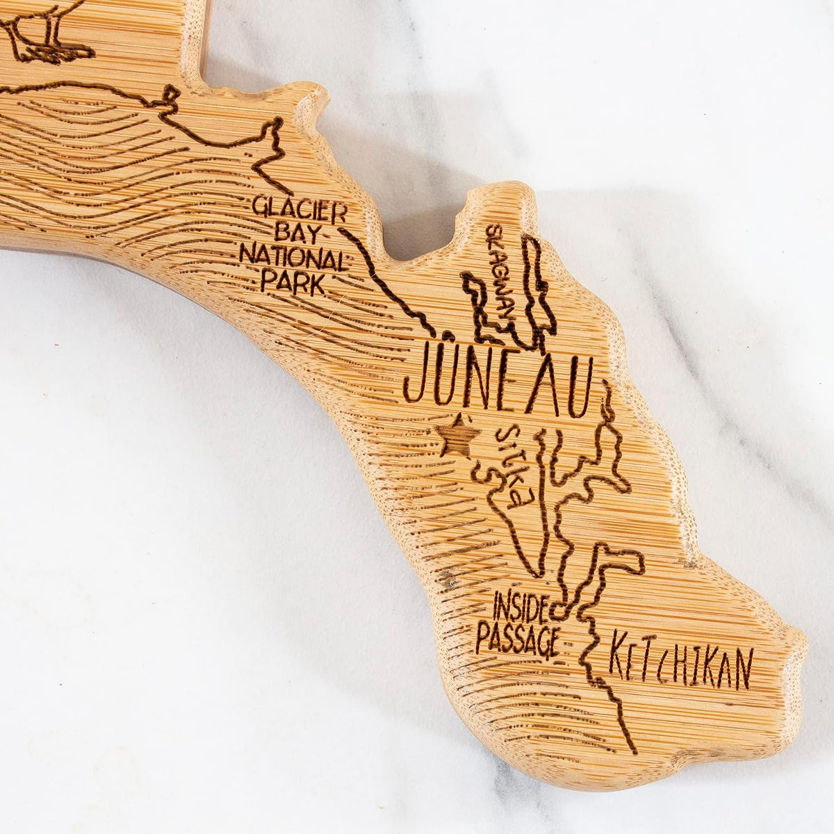 Destination Alaska State Shaped Cutting Board | State charcuterie serving board with engraved map artwork. Smooth reverse side for food prep. Hang tie for wall display.